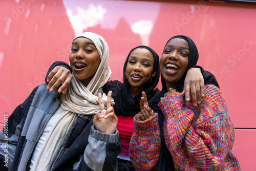 Portrait of smiling young women wearing hijabs photo
