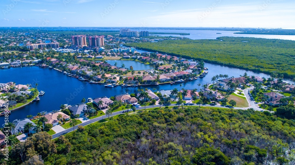 Aerial Drone View of Bay in Cape Coral, Florida with Mangroves and Real Estate in the Foreground and the Caloosahatchee River in the Background