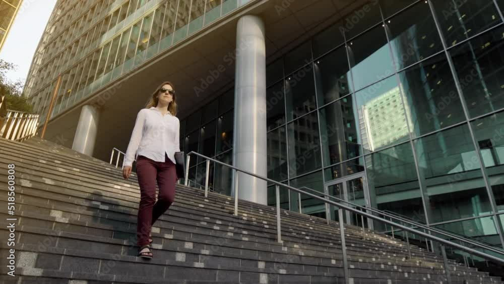 successful young woman walking in central business district in modern city. Big City Businesswoman Uses Laptop Computer. successful young woman walking in central business district in modern city. Big City Businesswoman Uses Laptop Computer.