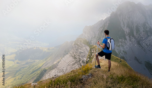 Solo hiker admiring the view on top of a mountain. French Alps view of the Col des Aravis - tourism and vacation - Pointe de Merdassier