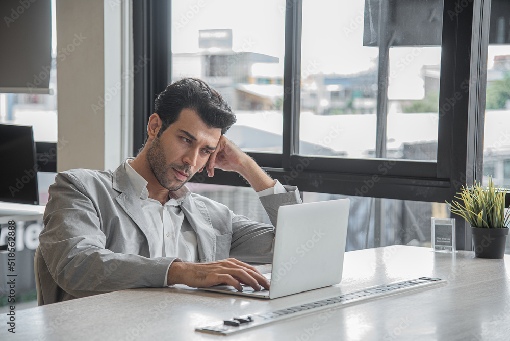 Business man serious and worry working with computer notebook in modern office Business man serious and worry working with computer notebook in modern office