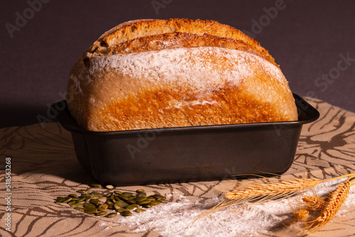 Freshly baked fresh dough bread with golden crust in loaf pan.