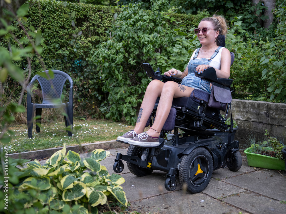 Woman in electric wheelchair in back yard Stock Photo | Adobe Stock