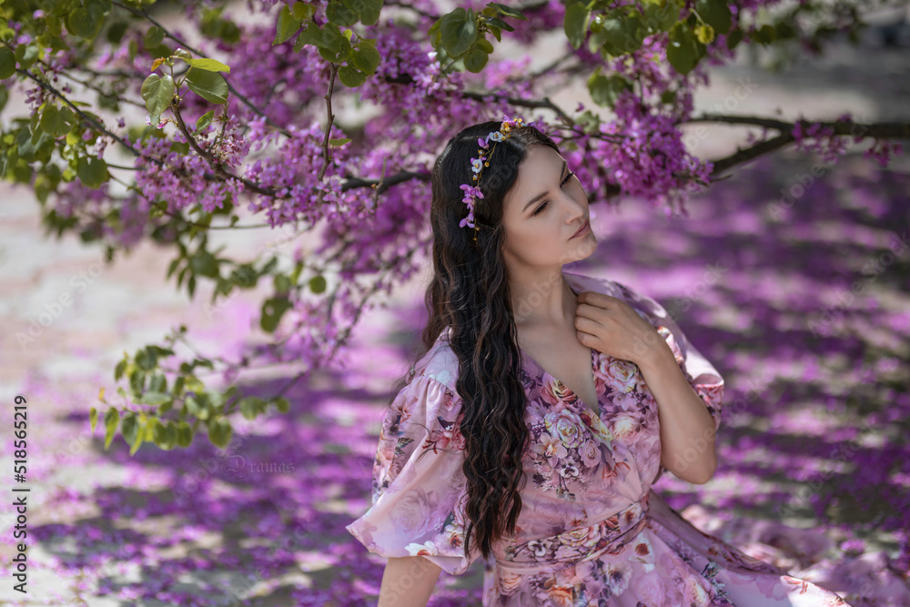 Dark-haired girl among the pink petals 