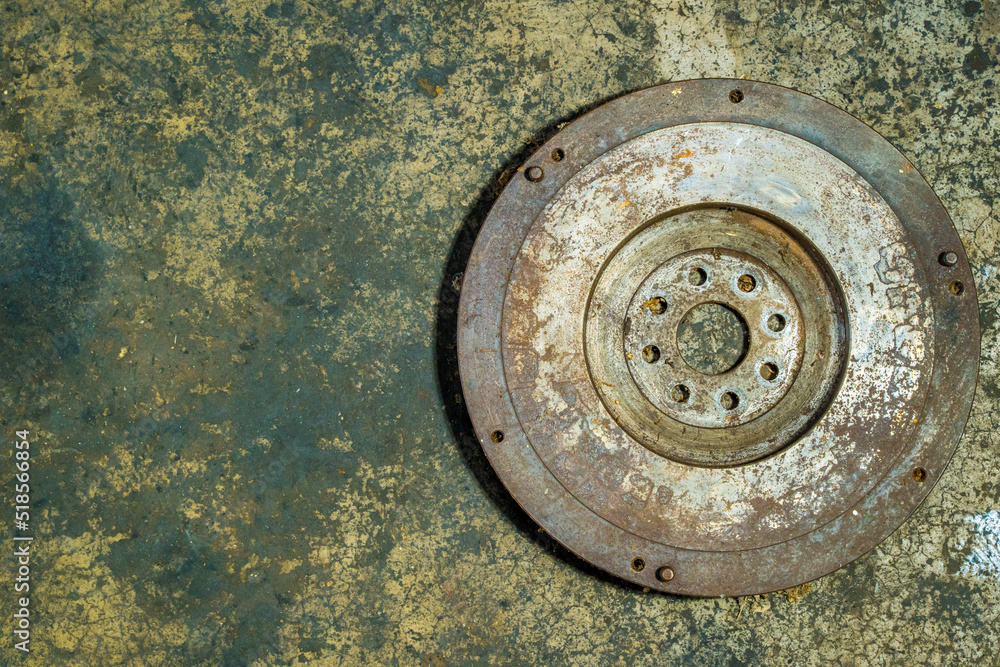 old flywheel clutch on dirty background.There are rust stains