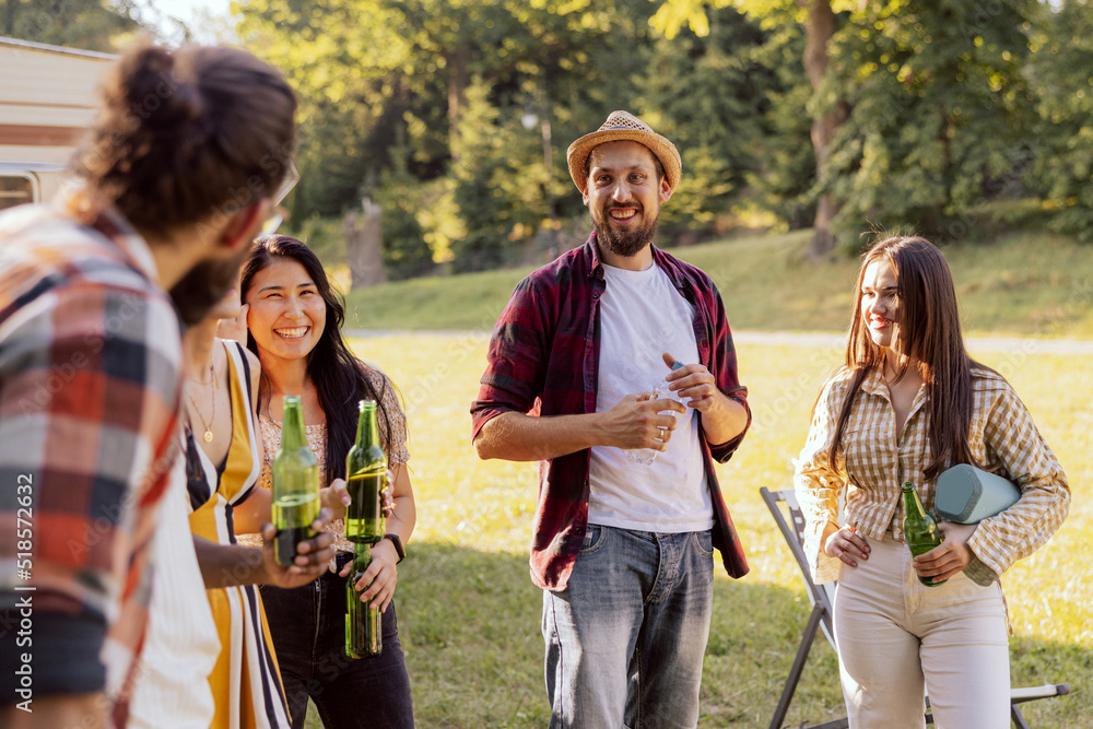 A happy group of middle-aged friends are traveling the world in an RV. The young people meet at a campsite. A happy group of middle-aged friends are traveling the world in an RV. The young people meet at a campsite.