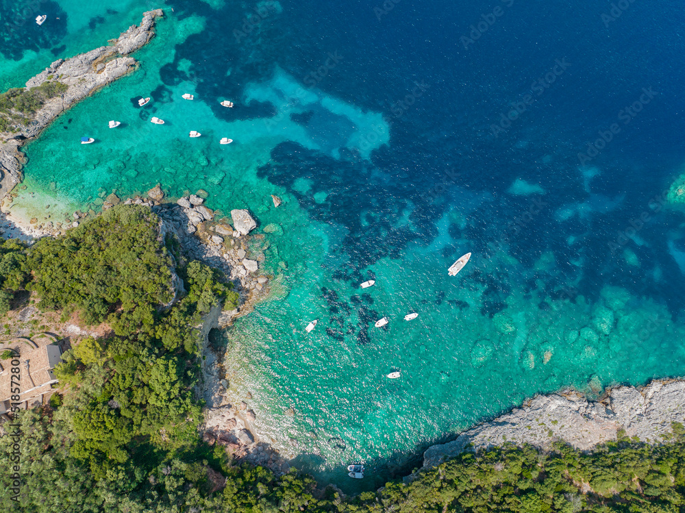Aerial view of Klimatia Beach, close to Limni beach on the island of Corfu. Coastline. Transparent and crystalline water, moored boats and bathers. Vacation. Greece
