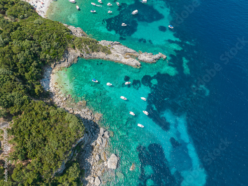 Aerial view of Klimatia Beach, close to Limni beach on the island of Corfu. Coastline. Transparent and crystalline water, moored boats and bathers. Vacation. Greece  © Naeblys