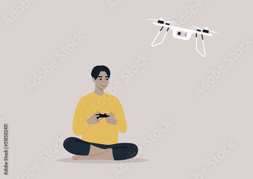 Fotografia A young male Asian character flying a drone with a remote control, new technolog
