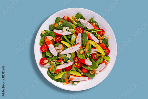 Crab sticks with tomatoes, spinach, parsley, avocado, celera, basil and almond slices photo
