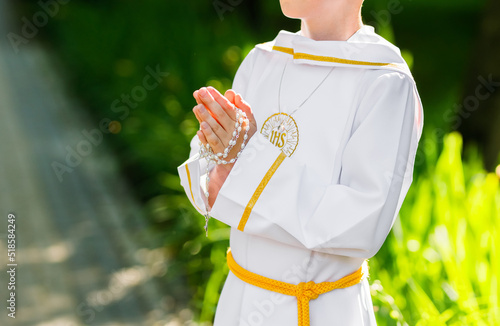 Pierwsza komunia święta. Dziecko trzymające różaniec, modlitwa