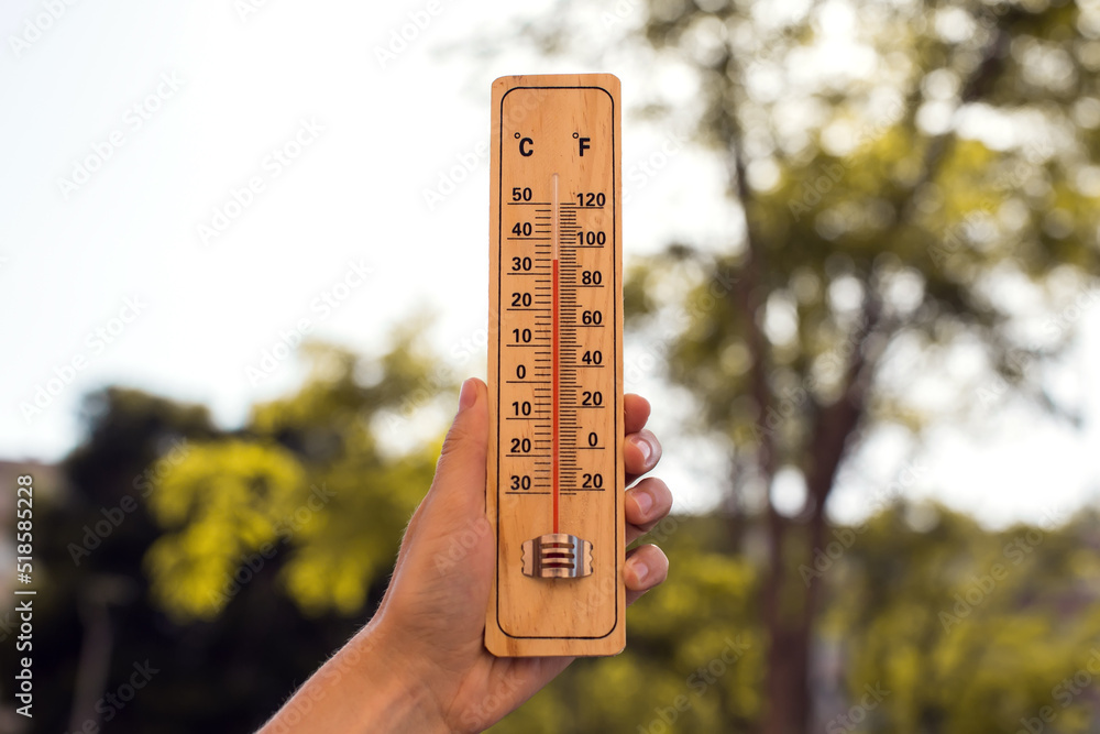 Hot weather. Thermometer in front of an urban scene during heatwave. Hot weather. Thermometer in front of an urban scene during heatwave.