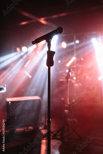 Canvas Print The microphone stands on the stage, illuminated by red light