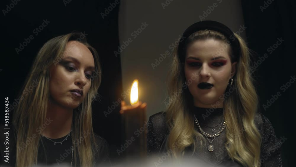 4K. Two female witches in a dark room reading tarot cards 4K. Two female witches in a dark room reading tarot cards