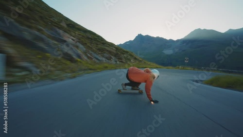 Cinematic downhill longboard session. Young woman skateboarding and making tricks between the curves on a mountain pass. Concept about extreme sports and people photo