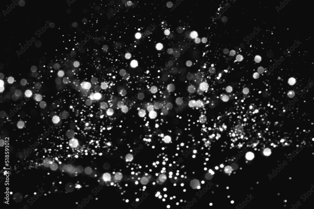 White gray blurred abstract bokeh lights on black background. Snowy shiny glitter sparkle stars for celebrate