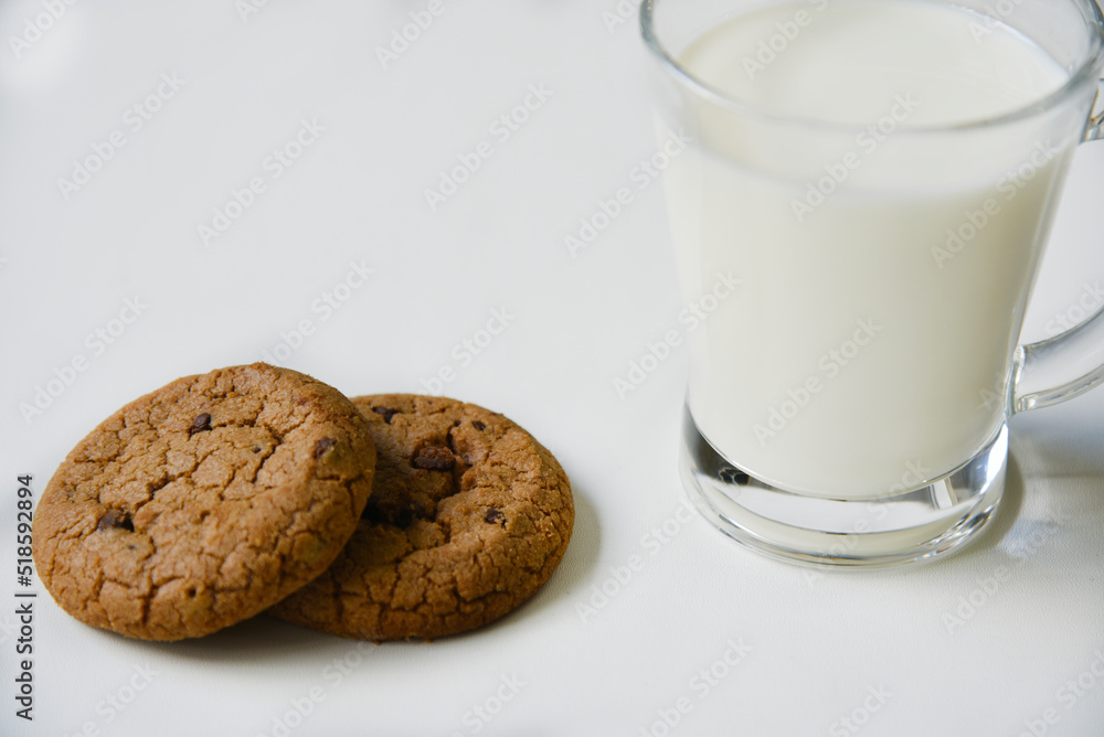 Glass glass with milk on a white background with oatmeal cookies. Afternoon lunch with cookies. Sweet cookies with milk. Glass glass with milk on a white background with oatmeal cookies. Afternoon lunch with cookies. Sweet cookies with milk.