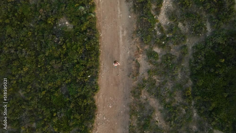 A young girl with a smartphone watching a drone go up A young girl with a smartphone watching a drone go up