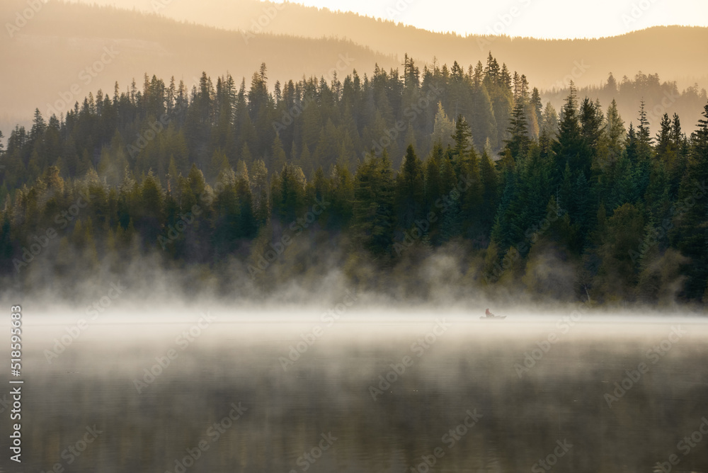 Fototapeta premium Lone kayak on calm, smoky water at Trillium Lake near Mt. Hood.