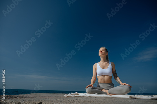 Yoga practice and meditation in nature. Woman practicing near Black sea.