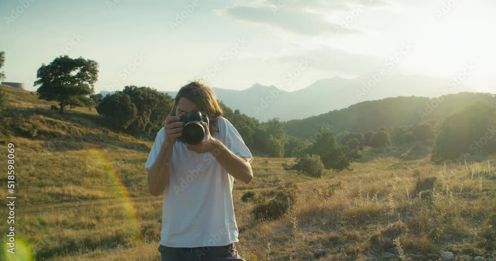 Inspired creative travel photographer make picture on DSLR camera at summertime journey. Hipster guy in mountain trip using photo equipment. Traveler influencer making content for blog or social media Inspired creative travel photographer make picture on DSLR camera at summertime journey. Hipster guy in mountain trip using photo equipment. Traveler influencer making content for blog or social media