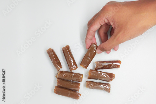 Dodol in hand. Dodol is a traditional snack from Indonesia with a sweet taste. Isolated on a white background photo