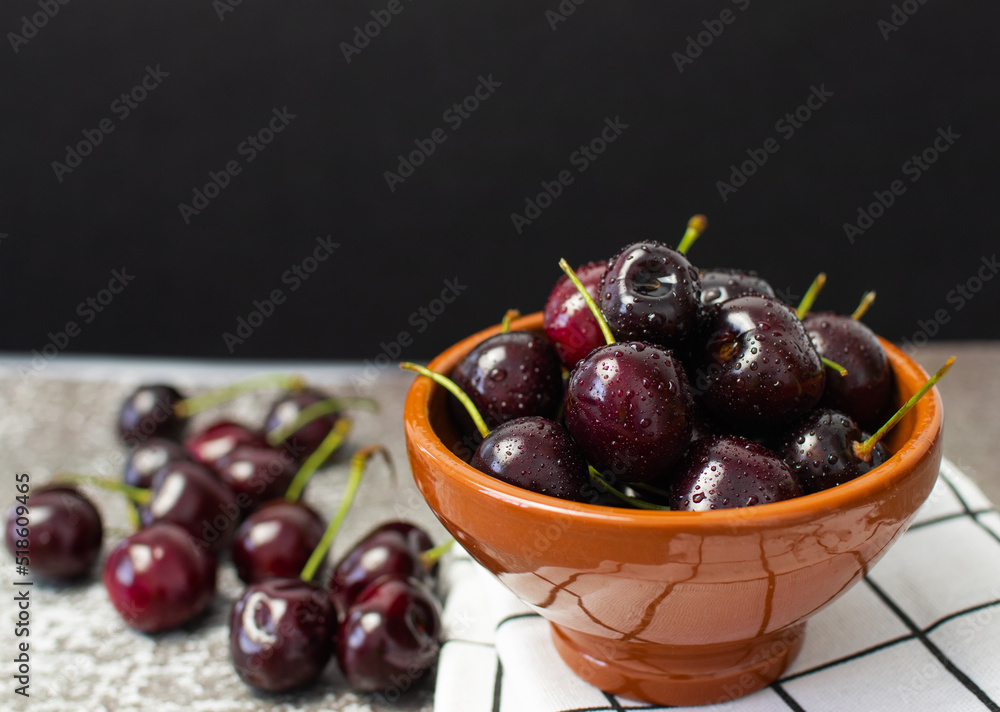Cherries with drops in a bowl on a black background Cherries with drops in a bowl on a black background