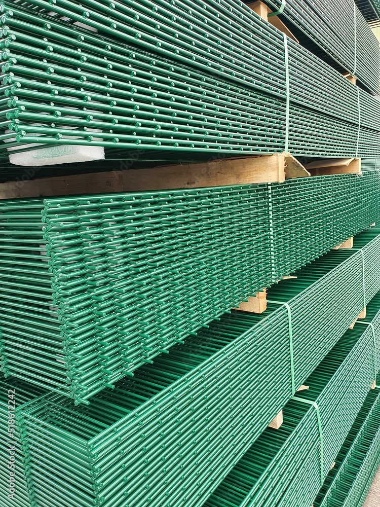 Stack of twin wire welded mesh fencing, powder coated in green Stock ...
