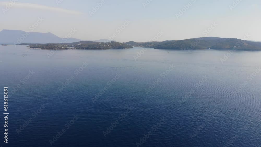 Pull out drone shot above clear blue waters in the Ionian sea. A little fishing boat appears midway through the shot Pull out drone shot above clear blue waters in the Ionian sea. A little fishing boat appears midway through the shot