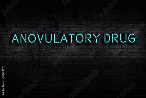 Night view of neon sign on brick wall with inscription anovulatory drug photo