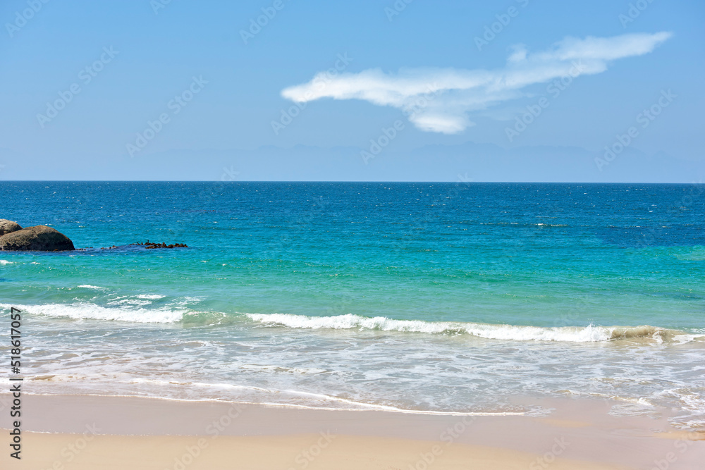 Calm beach with white sand by a natural seaside environment in a popular getaway location for a holiday in Cape town. Landscape of the ocean on a sunny day with blue sky and copy space