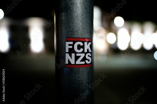 Close-up shot of the FCK NZS popular anti-nazi acronym posted on a street pole photo