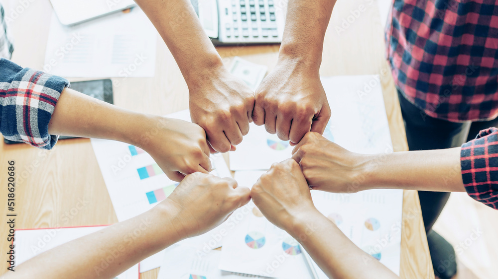 Obraz premium close up hand of business partnerships people bump hands finishing up meeting showing unity over office desk , business teamwork concept