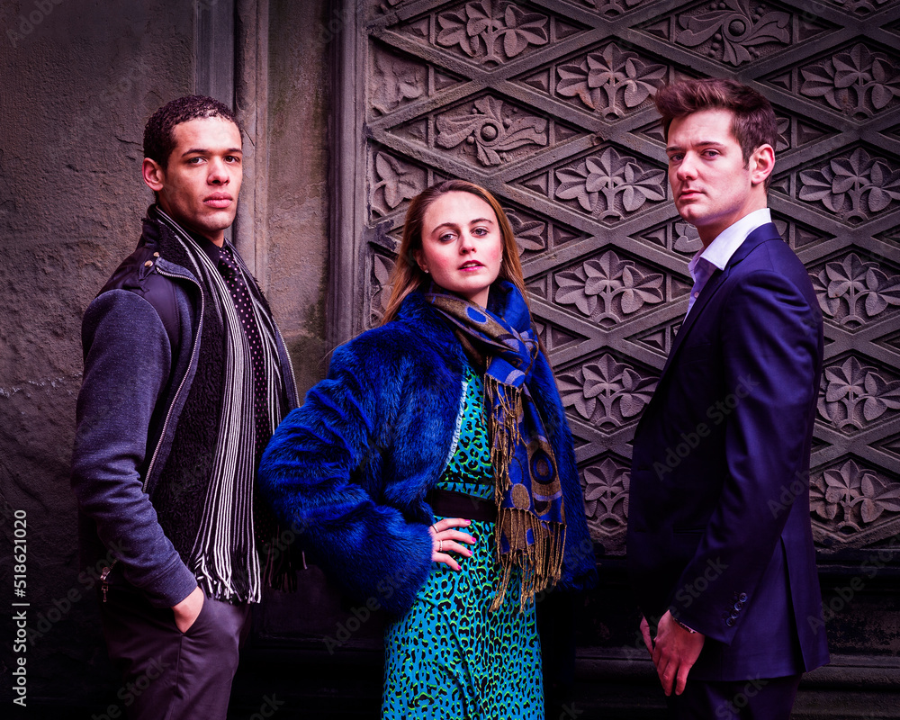 Three Friends. Three students, two young men and one young woman, are confidently standing there and looking forward..