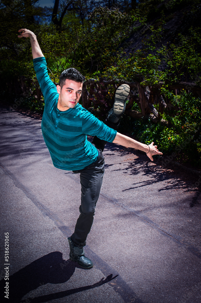 Dancing in Park. Young man, stretching arms, legs, dancing in park in New York City.