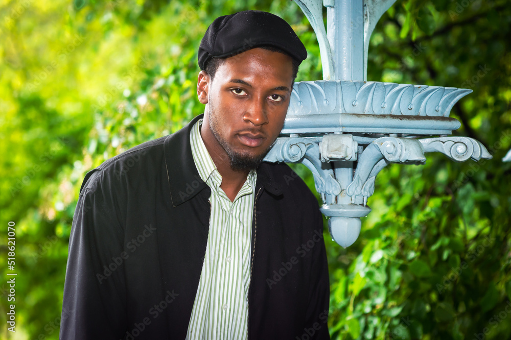 Green. Young black man seriously looking at you..