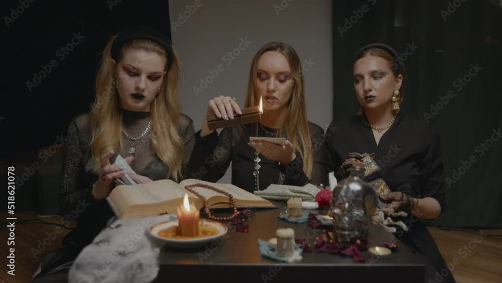 4K. Three female witches in a dark room conduct mystical sessions 4K. Three female witches in a dark room conduct mystical sessions