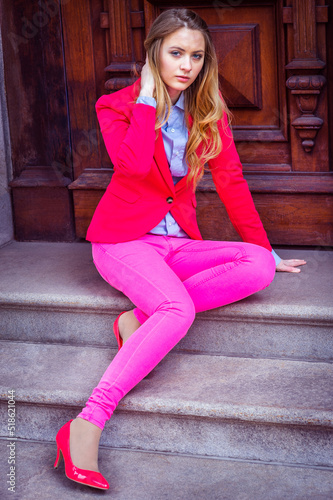 Obraz na płótnie Girl Dressing in Pink. Young teenage girl wearing pink blazer, pink pants, pink shoes, sitting on stairs by office door. w salonie