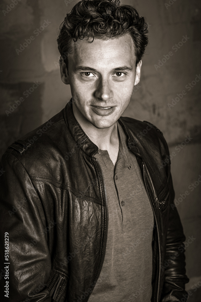 Portrait of Young Man in New York City. Young man wearing black leather jacket, charmingly looking forward. Black and White Photography