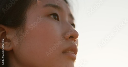 Close up face of Asian girl, looking at the sky outdoors
