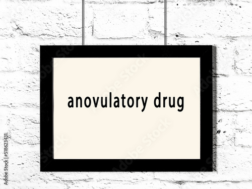 Black frame hanging on white brick wall with inscription anovulatory drug photo