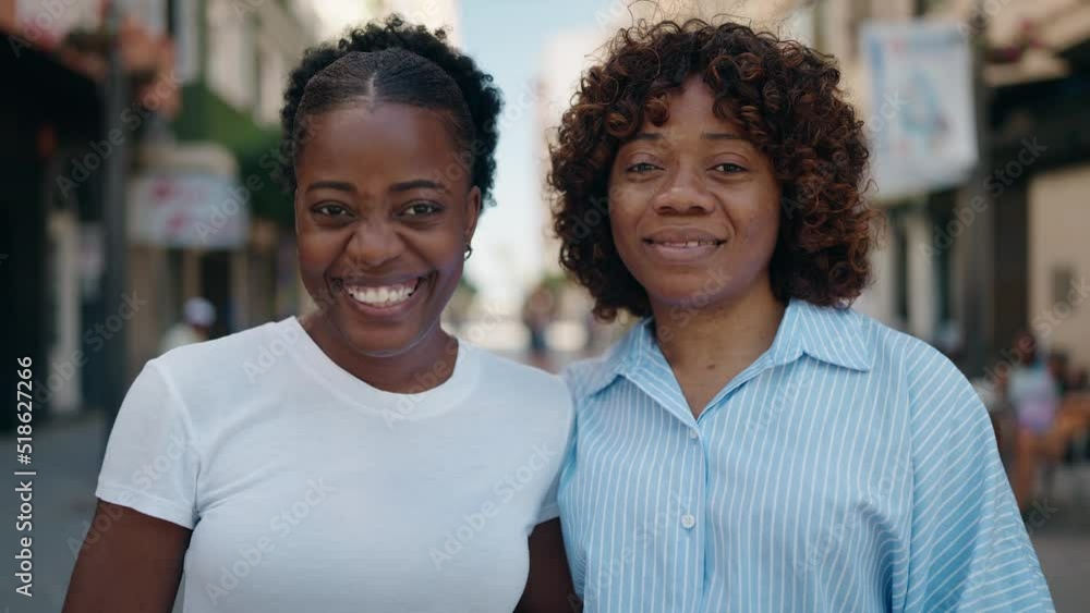 African american women mother and daughter hugging each other at street African american women mother and daughter hugging each other at street