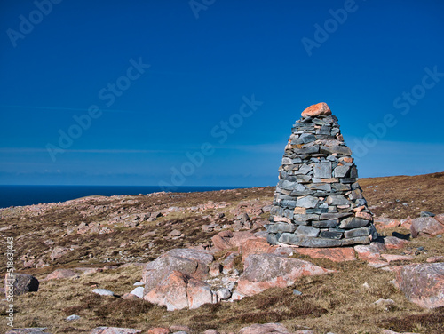 A cairn and pink granite near the neolithic axe factory in the Beorgs of Uyea, Northmavine, Shetland, UK. Igneous bedrock of pink Ronas Hill Granite - Granite, granophyric. Taken on a sunny day. photo