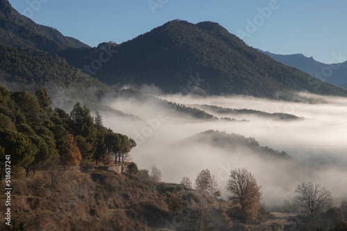 Landscape of mountains in mist and trees in Sant Llorens de Morunys town in Catalonia photo