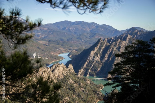 Landscape of mountains and Llosa del Caval swamp among some branches in the foreground in Catalonia photo