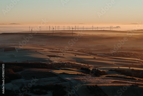 Beautiful shot of fields and windmills illuminated by the golden evening in a town in Germany photo