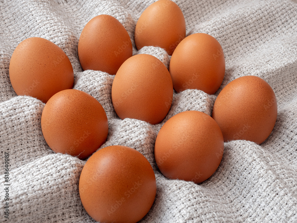 group of brown chicken eggs on a grey table linen cloth group of brown chicken eggs on a grey table linen cloth