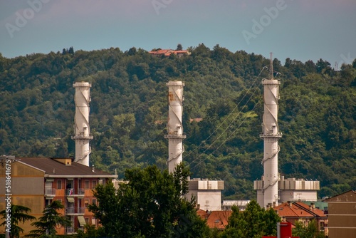 Tall towers at the foot of the forested hills in Chivasso, Italy