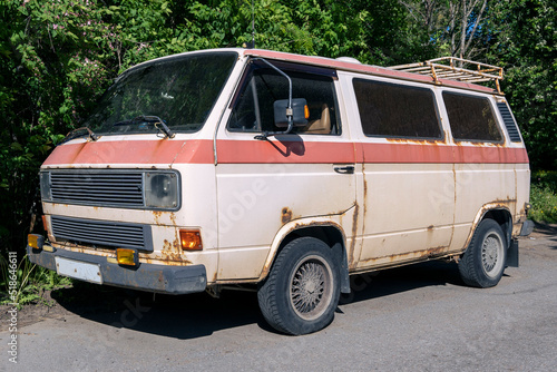 an old vintage rusty minibus standing in the yard. hippie culture