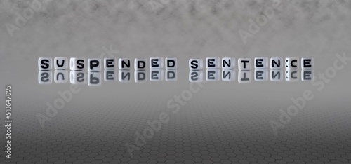 suspended sentence word or concept represented by black and white letter cubes on a grey horizon background stretching to infinity
